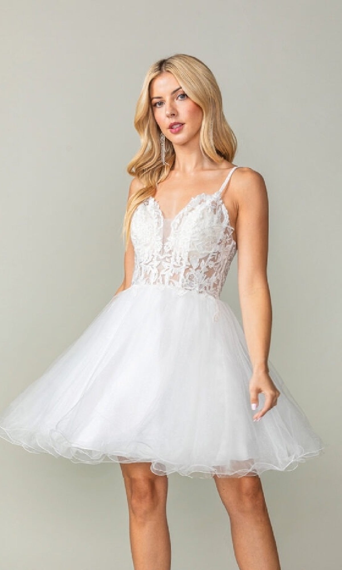 Woman wearing a white short dress against a plain background